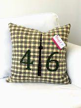 Load image into Gallery viewer, Cream pillow with chocolate brown squares. Moss numbers and plaid CN Tower.
