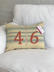 Cream pillow with blue stripes. Rust numbers and cream CN Tower