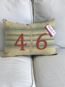 Cream pillow with blue stripes. Rust numbers and cream CN Tower