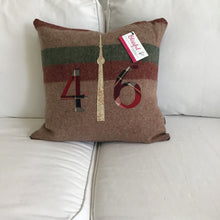 Load image into Gallery viewer, Light brown pillow with maroon and moss stripes. Maroon plaid numbers and cream CN Tower.
