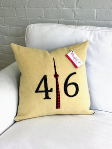 Cream pillow with black/grey check numbers and red plaid CN Tower.
