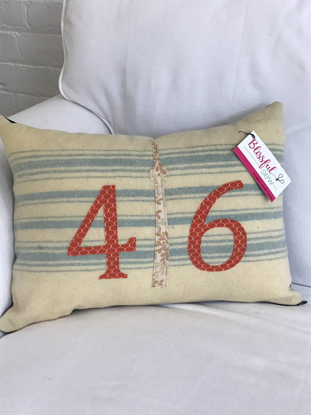Felted Wool Blanket Pillow - Cream background with multiple robins egg blue stripes. Rust colored numbers and mottled cream CN Tower