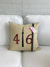Load image into Gallery viewer, Cream pillow with modern black stripe. Red plaid numbers and black CN Tower.
